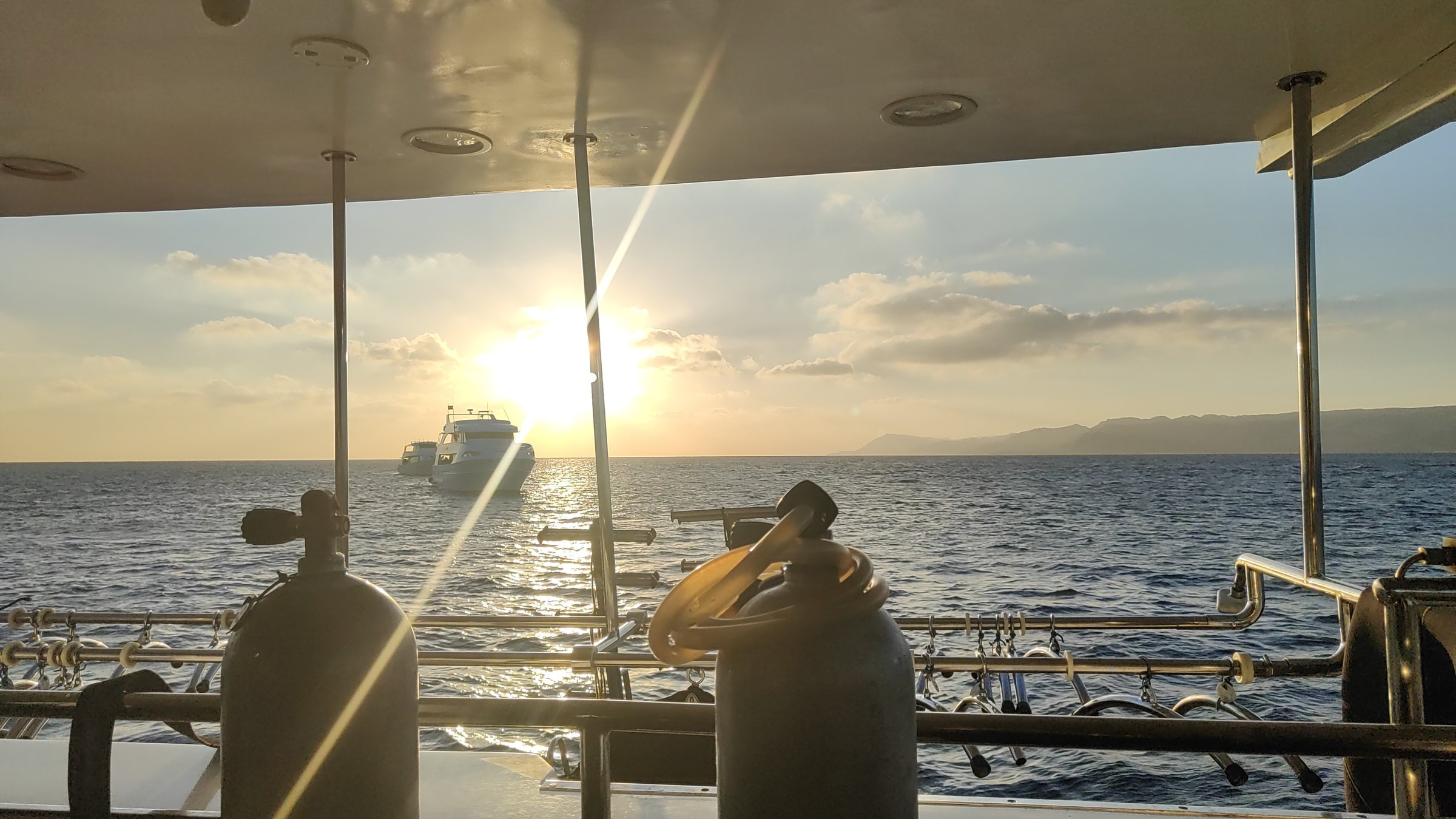 Blick vom Tauchdeck eines Safarischiffs im Roten Meer bei Sonnenuntergang, im Vordergrund Tauchflaschen